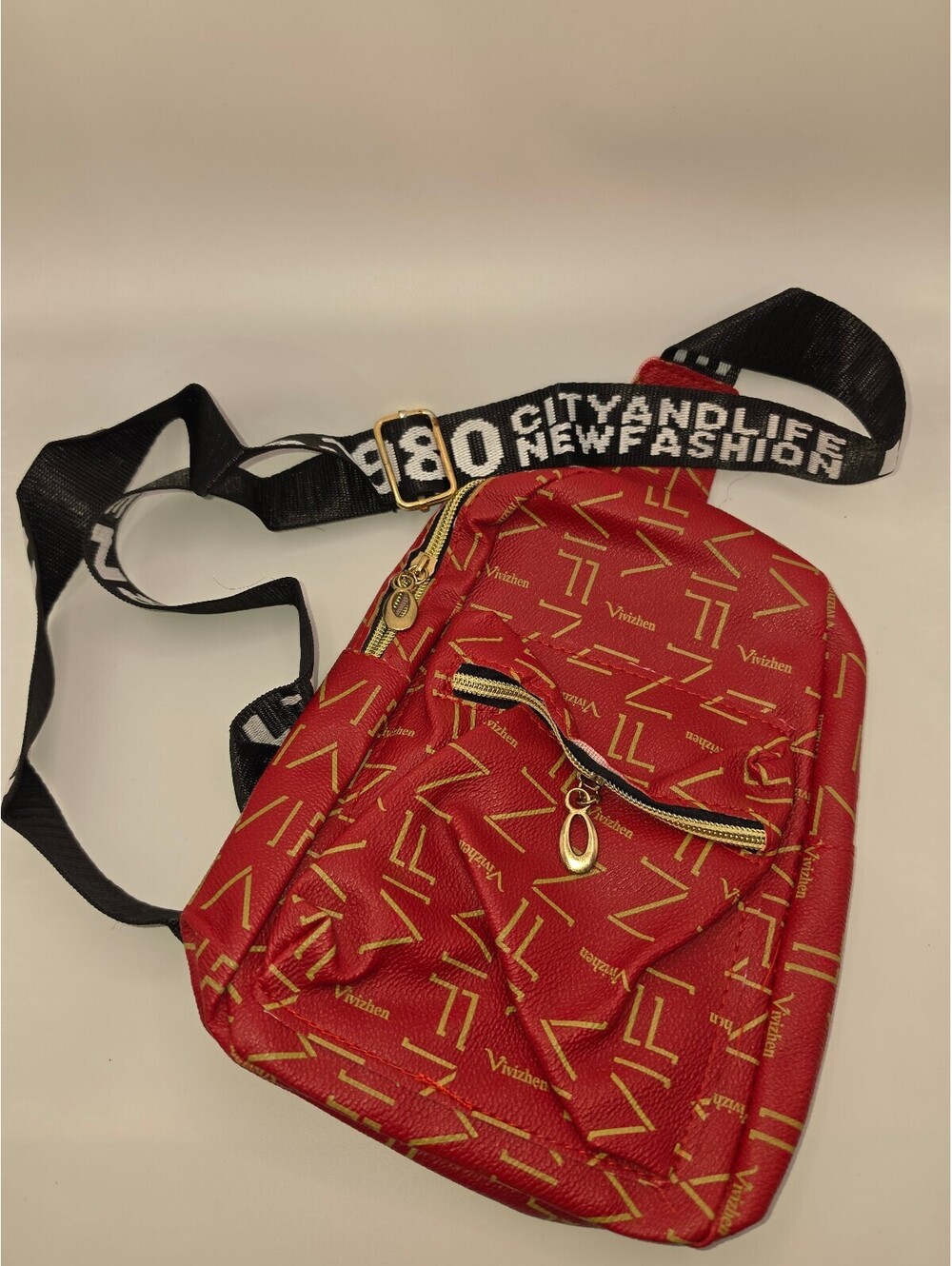 Red Crossbody Bag with Black and White Adjustable Strap and Gold Zipper Accents